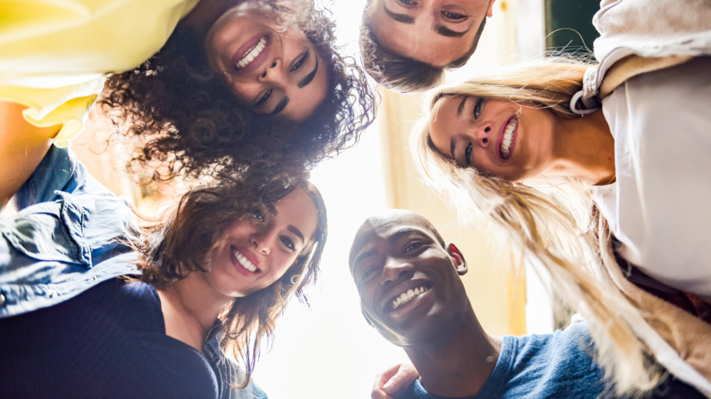 group of people in a circle looking down at the camera